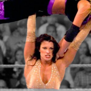 Victoria (Lisa Marie Varon) military presses Trish Stratus. The pair had some hard-hitting affairs and always gave their all when they met in the ring.