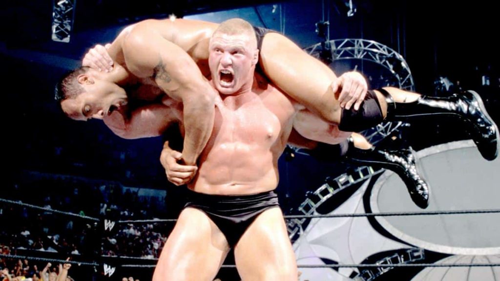 Brock Lesnar holding the Rock on his shoulders before slamming him on the mat