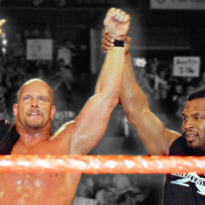 Iron Mike Tyson raises Stone Cold Steve Austin's hand in victory after winning his first WWF Championship at WrestleMania 14 in 1998.