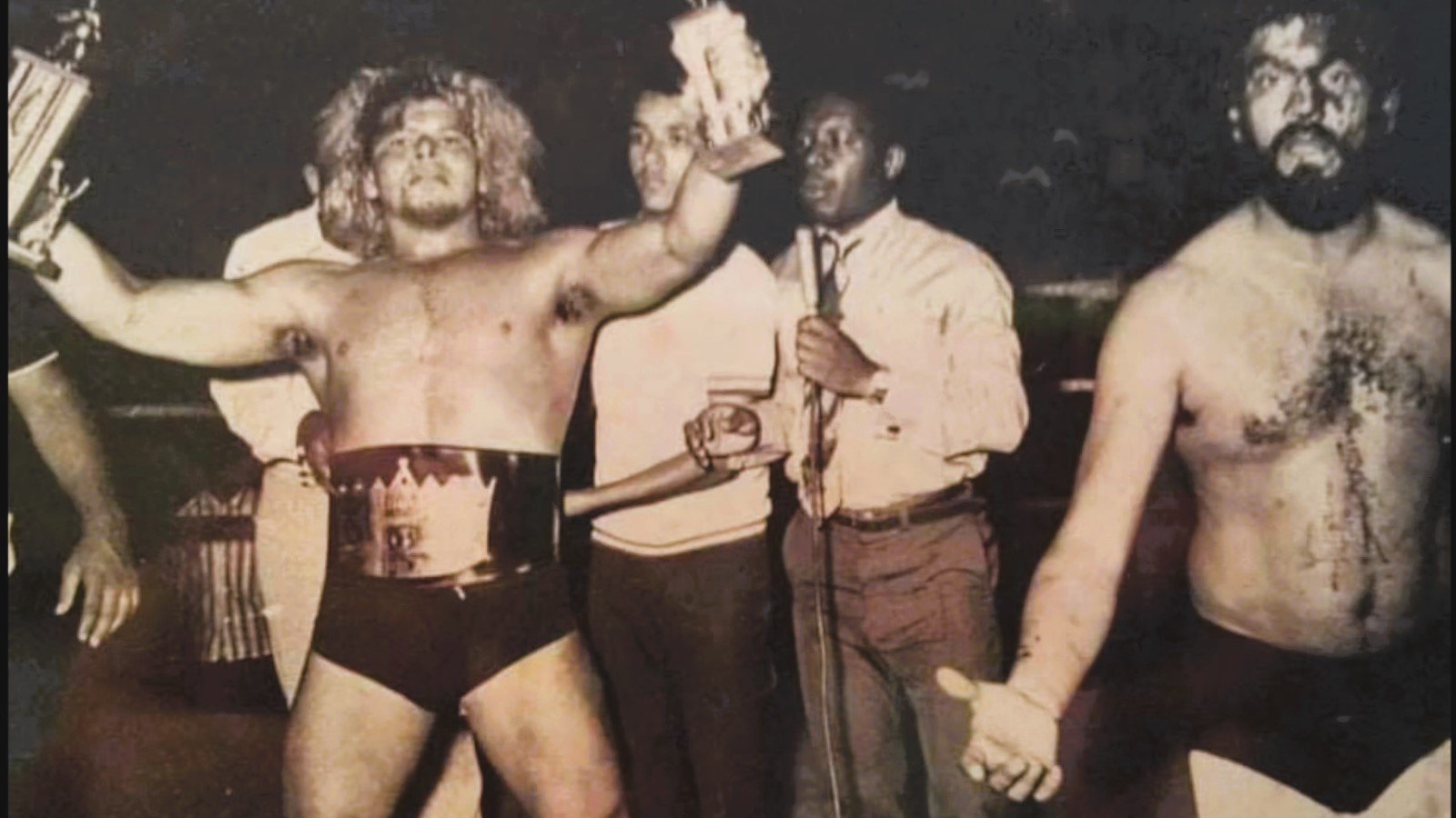 Salvador Pérez El Vikingo as champion in Dominican Republic with bloodied wrestling legend Jack Veneno looking stunned after their brutal encounter. 
