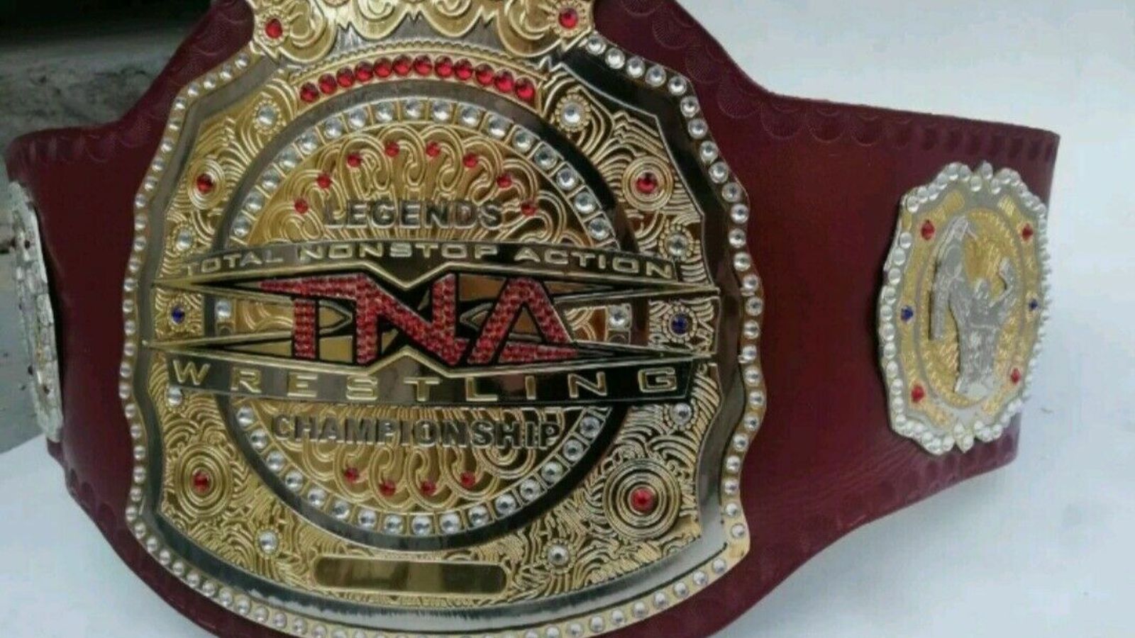 The TNA Legends Championship, which debuted in 2008, was first worn by Booker T, famed for its vivid red strap, layered gold plates, and crown emblem representing TNA authority.