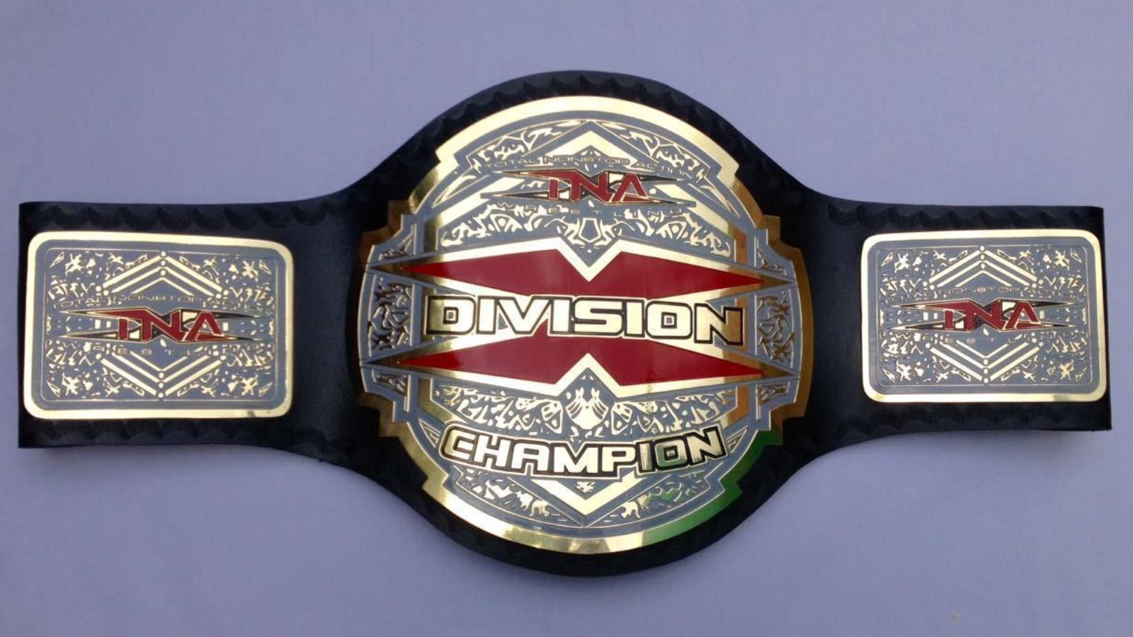 The TNA X-Division Championship (2005 redesign), first held by AJ Styles, features an iconic oversized red 