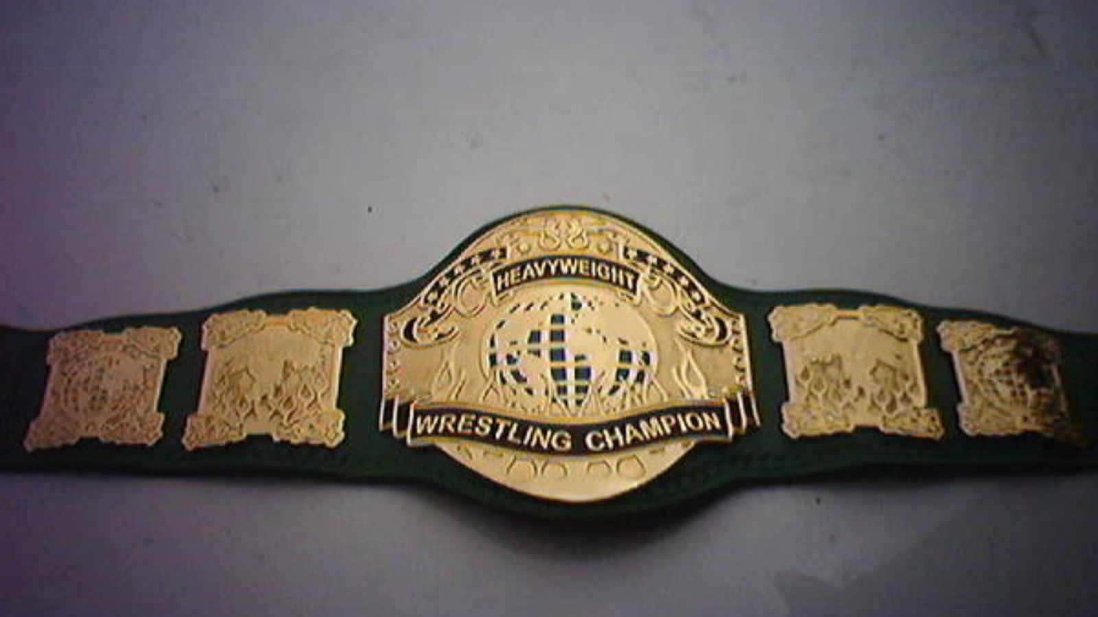 The PWG World Championship, launched in 2003 with Frankie Kazarian, features forest-green leather and throwback gold plating, symbolizing the pride of indie wrestling. 