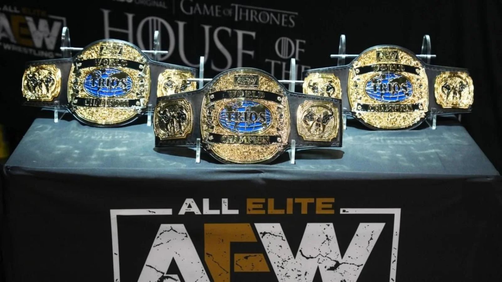 The AEW World Trios Championship, unveiled at All Out 2022, is claimed by Kenny Omega &amp; The Young Bucks. The refined gold-globe plates on black leather seamlessly blend classic and modern aesthetics.