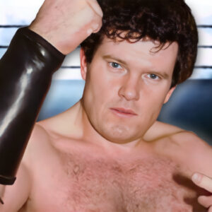 Professional wrestling Iron Mike Sharpe pointing at himself with his left hand while raising his right, clenched fist in the air.