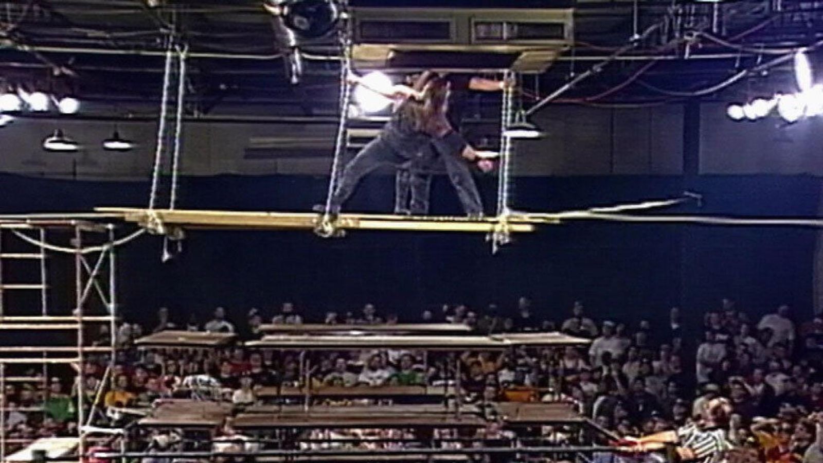 ECW High Incident (1996): Tommy Dreamer and ‘Prime Time’ Brian Lee fight atop a scaffold above the ring. Lee later falls through multiple stacked tables, a spot that cemented ECW’s high-risk legacy. 