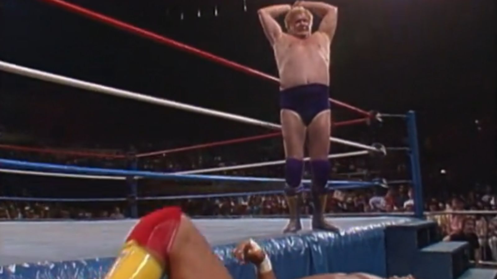 Saturday Night’s Main Event, March 1988: King Harley Race perches on the ring apron, eyeing Hulk Hogan lying atop a ringside table. Race then dives, but Hogan narrowly escapes, breaking the table. 
