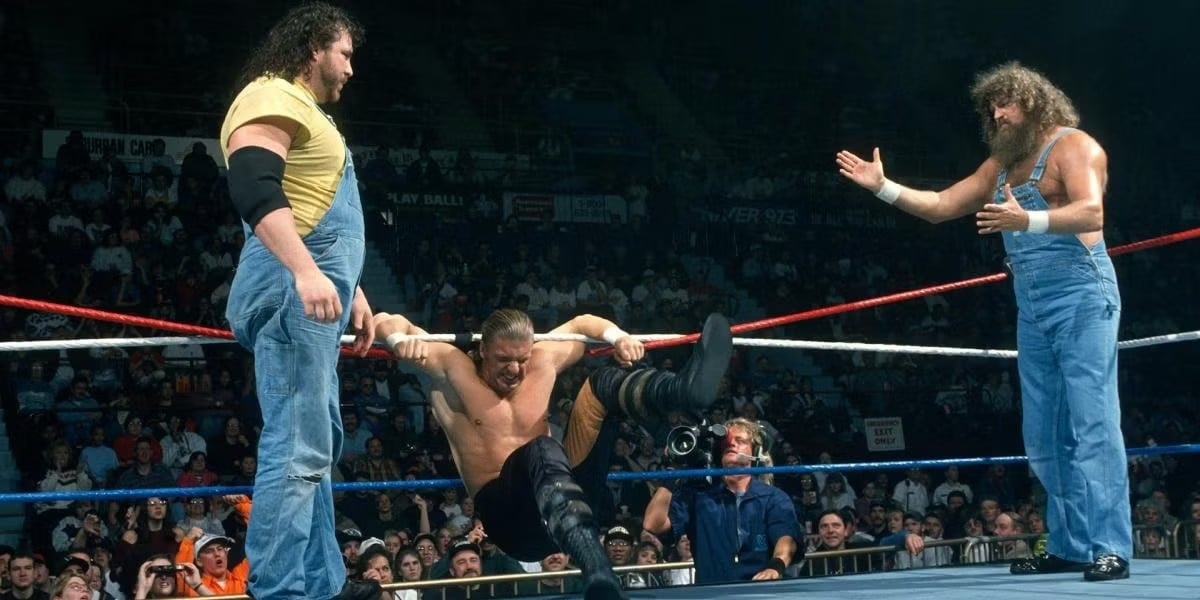 Henry O. Godwinn and guest referee Hillbilly Jim during the Arkansas Hog Pen Match while Hunter Hearst Helmsley is tangled in the ring ropes at WWE In Your House 5. 