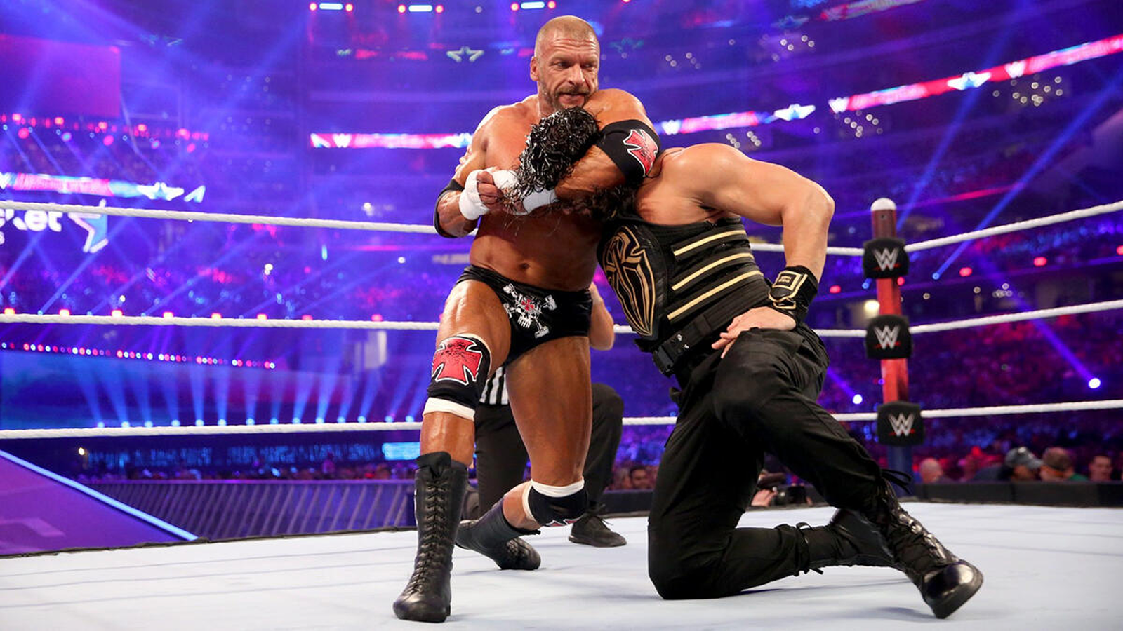 Triple H grounds Roman Reigns during WrestleMania 32’s polarizing main event where Reigns claimed the WWE Championship amid heavy boos.