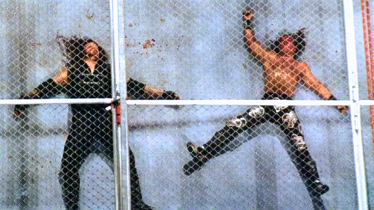 Shawn Michaels and The Undertaker lie battered and bloodied inside the ring following the first-ever Hell in a Cell match at Badd Blood: In Your House on October 5, 1997, in St. Louis, Missouri. Captured from high above the steel structure that changed WWE forever, this iconic shot embodies what Hell in a Cell came to represent – pain, sacrifice, and legacy.