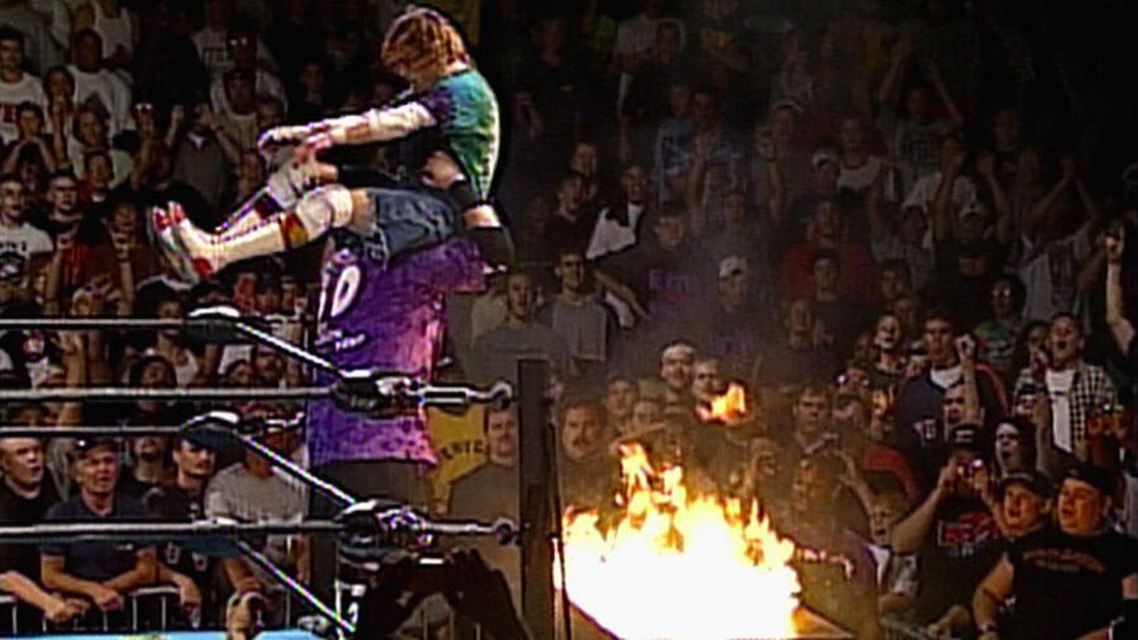 ECW Arena, 1995: Hardcore legend Spike Dudley is moments away from being powerbombed through a flaming ringside table. ECW’s death-defying gimmicks pushed table spots to extremes. 