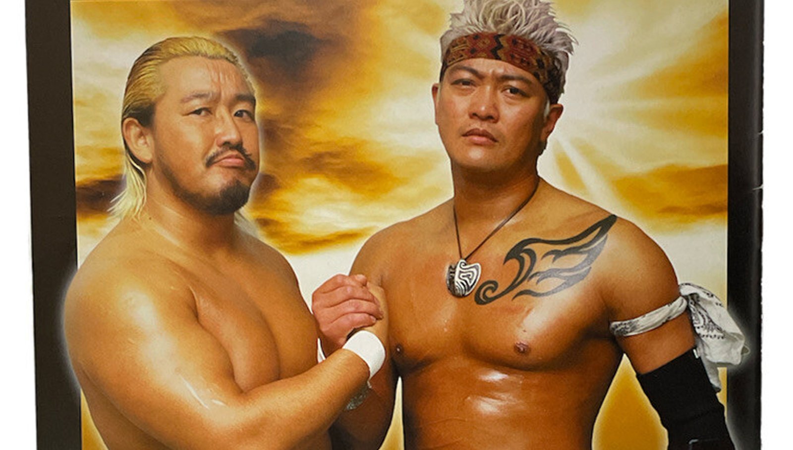 Eiji Ezaki (right) unveils his unmasked 'H' persona on the FMW 2000 Official Guide Book, representing a dramatic character evolution during his later FMW career. This departure from the traditional Hayabusa masked character signaled a shift in wrestling style and marked a new chapter in his professional wrestling journey. 