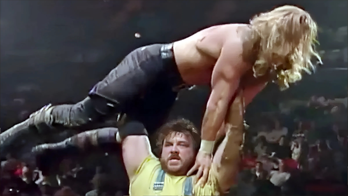 Henry O. Godwinn hoists Hunter Hearst Helmsley (Triple H) above his head during their infamous Arkansas Hog Pen Match at In Your House 5 in December 1995. 