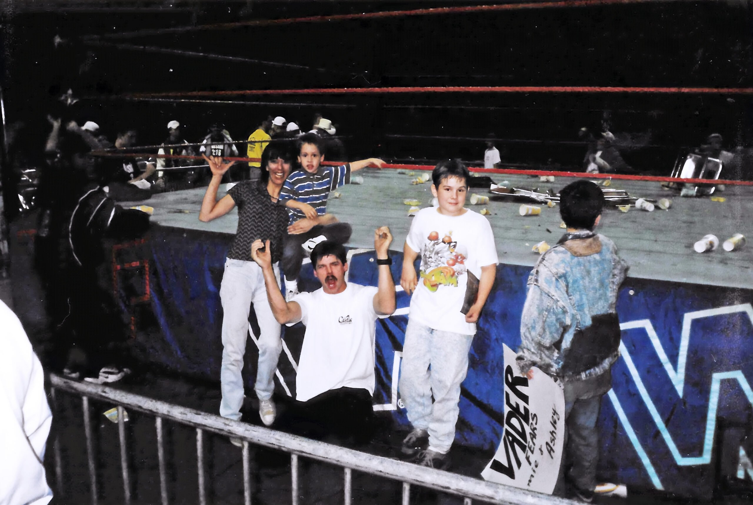 Ryan Henslee poses ringside after 1997 WWE Little Rock riot at Barton Coliseum holding Vader fears Jamie and Ashley sign