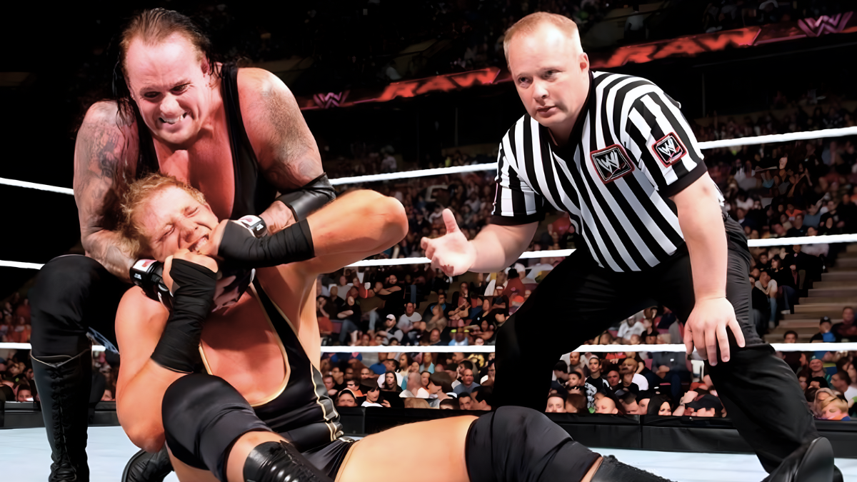 WWE wrestling referee Jack Doan monitors wrestler safety as The Undertaker applies a chin lock on "The All-American American" Jack Swagger during Monday Night Raw on April 19, 2010. 