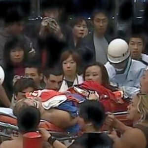 Eiji Ezaki (Hayabusa) is stretchered out of the FMW ring on October 22, 2001, after tragedy struck during his final match against Mammoth Sasaki. The devastating moment left horrified wrestlers and fans watching as one of professional wrestling’s most innovative high-flyers faced an uncertain future. This tragic image remains one of wrestling’s most pivotal moments, with fellow performers like Chris Jericho reconsidering their own aerial techniques in light of the accident.