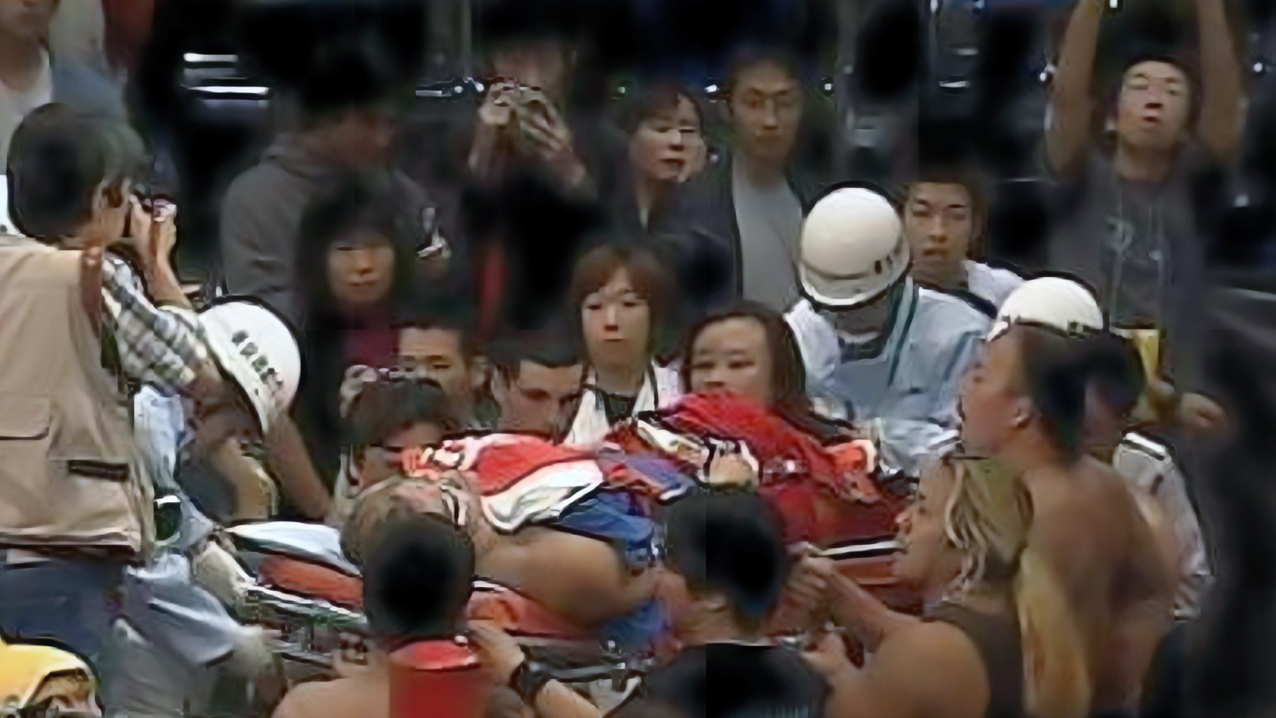 Eiji Ezaki (Hayabusa) is stretchered out of the FMW ring on October 22, 2001, after tragedy struck during his final match against Mammoth Sasaki. The devastating moment left horrified wrestlers and fans watching as one of professional wrestling’s most innovative high-flyers faced an uncertain future. This tragic image remains one of wrestling’s most pivotal moments, with fellow performers like Chris Jericho reconsidering their own aerial techniques in light of the accident.