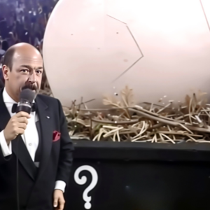 Mean Gene Okerlund stands beside the mysterious giant egg at Survivor Series 1990 as the Hartford Civic Center as the crowd buzzes over WWE’s bold Thanksgiving gamble that would hatch the Gobbledy Gooker.