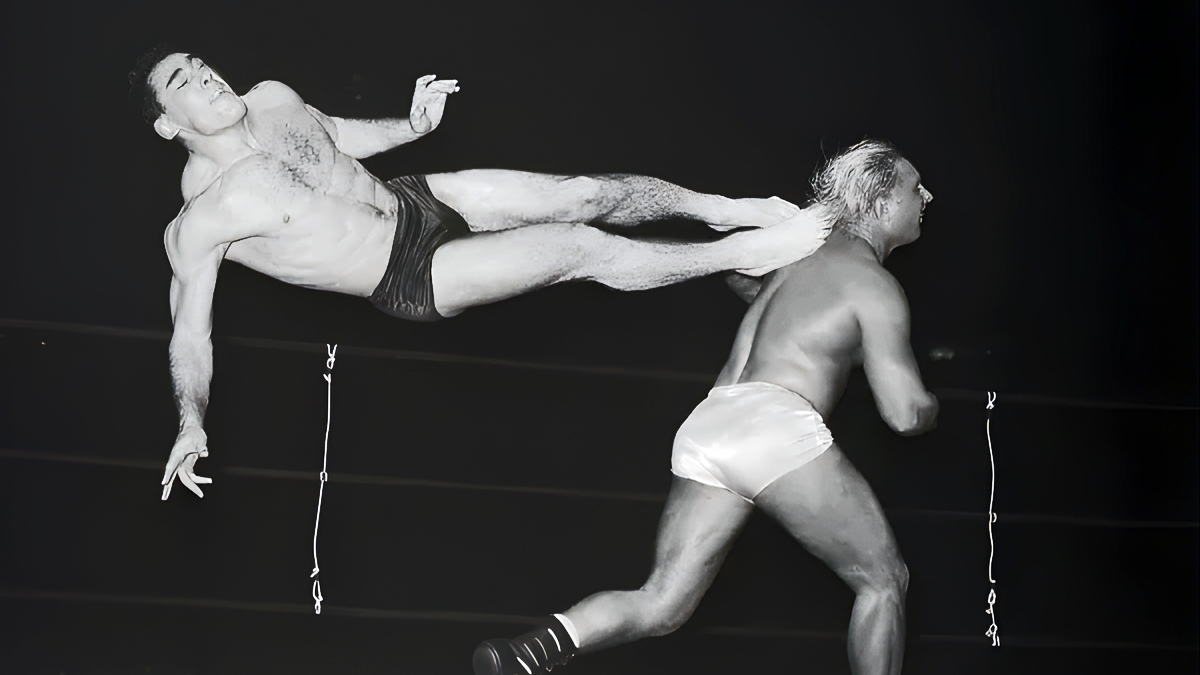 Antonino Rocca, one of the first professional wrestlers to own the air with aerial maneuvers, connects with a flying dropkick on Gene 