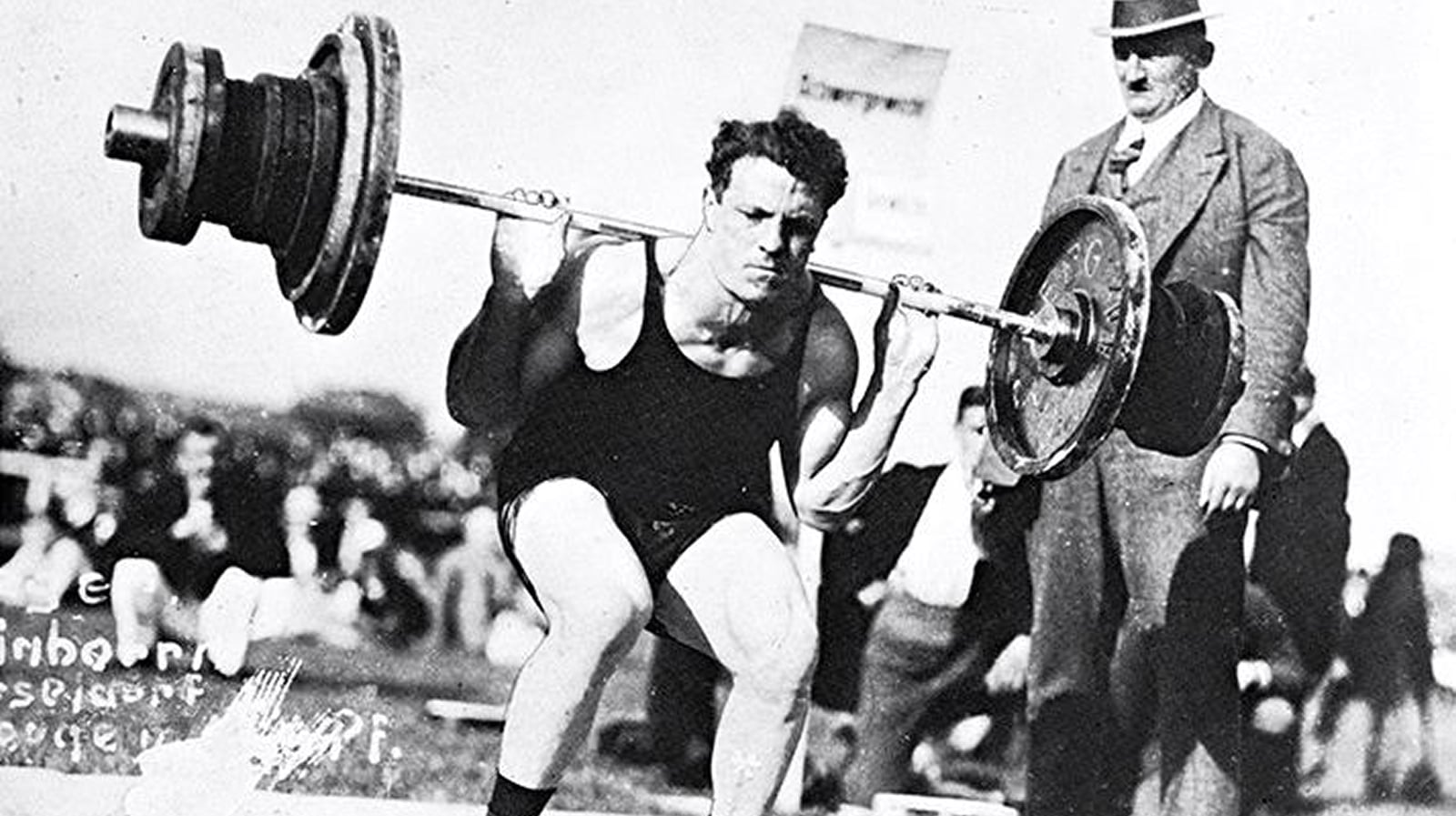 Milo Steinborn popularized the legendary Steinborn squat, as seen here, tipping a heavy barbell from the floor onto his shoulders for deep knee bends over 500 pounds with no rack.