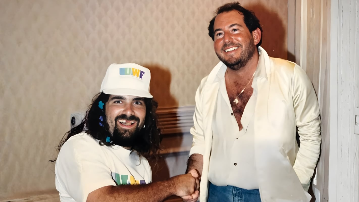 Mick Foley shakes hands with UWF founder Herb Abrams at John Arezzi's Wrestling Fans Fantasy Weekend convention in 1990. The handshake captured the optimism of the promotion's early days before unpaid talent, financial chaos, and Abrams' deteriorating behavior brought the UWF to its knees. 