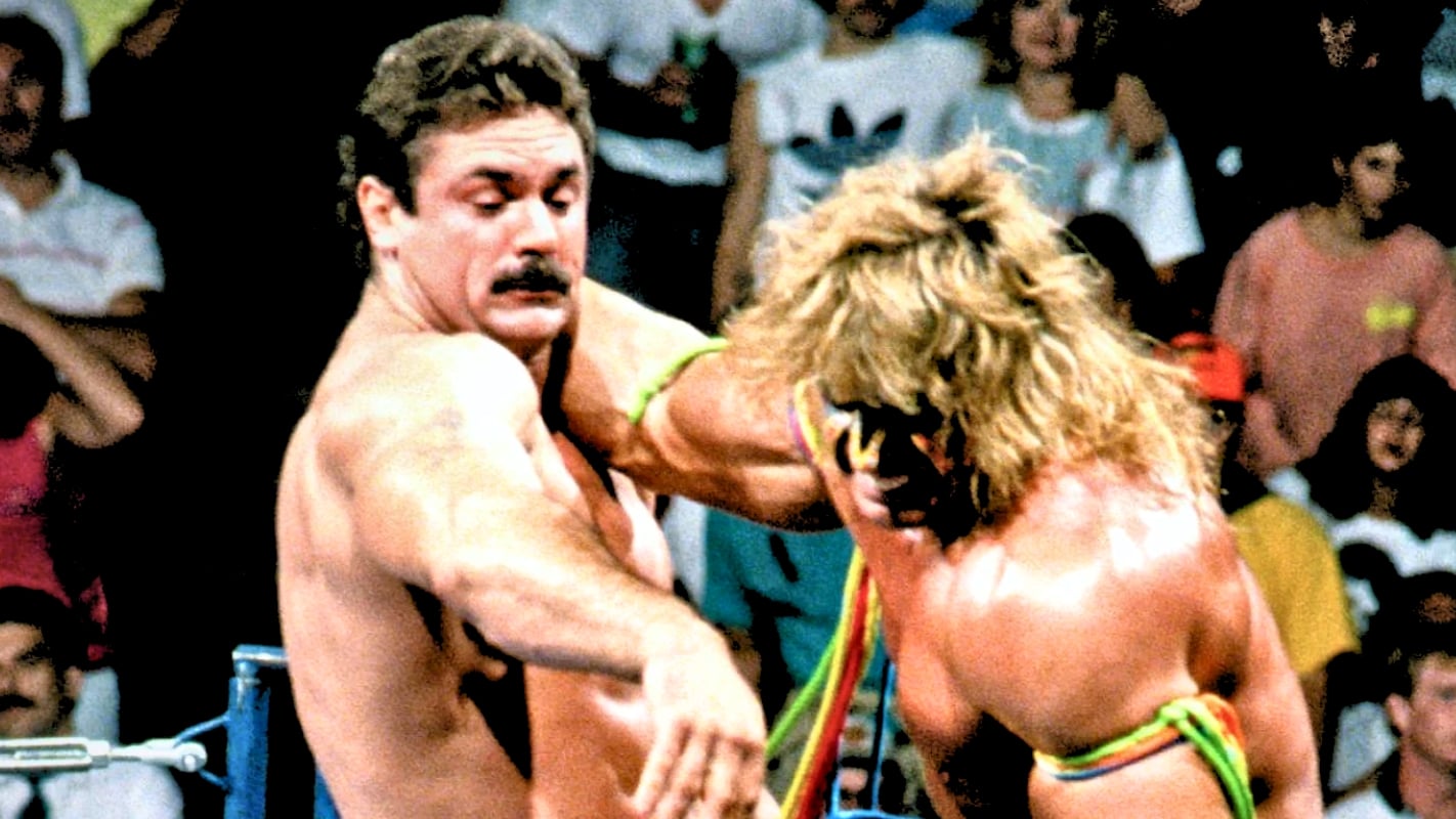 During a lumberjack match in Texas, Bushwhacker Luke recalls Rick Rude finally responding to Ultimate Warrior's stiff clotheslines by flooring him with a single punch, drawing on his Golden Gloves boxing background.