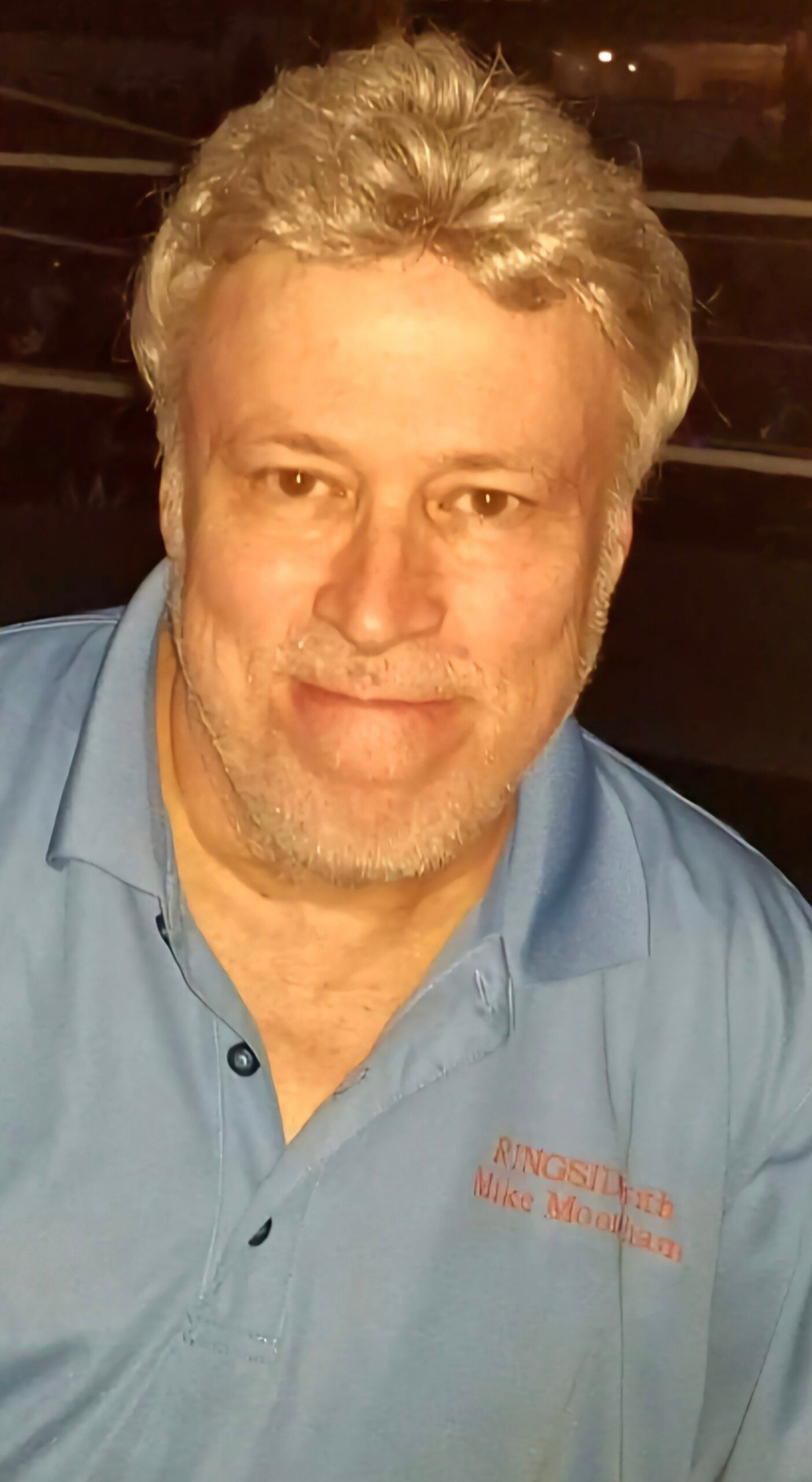 Mike Mooneyham stands ringside at a professional wrestling event, reflecting his decades of firsthand coverage in the sport.